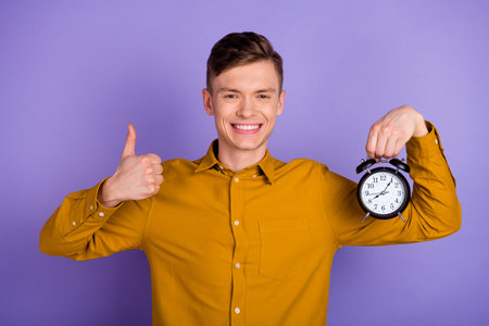 Photo of young excited man show thumb-up approve perfect alarm isolated over violet color backgroundの写真素材
