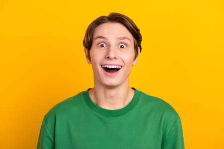 Photo of crazy amazed young man open mouth unbelievable information isolated bright color backgroundの写真素材
