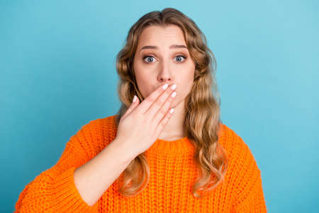 Shocked amazed young woman standing covering mouth with hands looking camera isolated studio portraitの写真素材