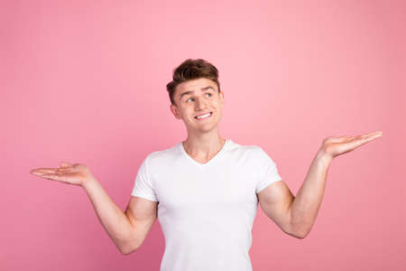 Photo of attractive guy hold open palms advertising two products low prices shopping isolated pastel color backgroundの写真素材