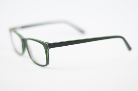Glasses with a black-green frame on a white background, blur, depth of field, side viewの写真素材
