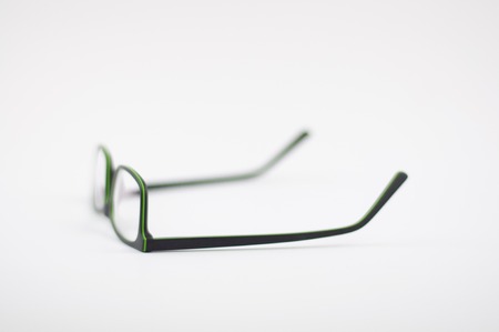 Glasses with a black-green frame on a white background, blur, depth of field, side view, upside downの写真素材