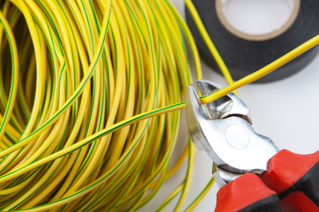 wire cutters, with a bundle of yellow-green wires and electrical tape, close upの写真素材