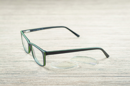 glasses and lenses for eyeglasses, closeup on the wooden table, blurの写真素材