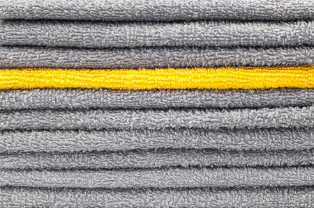 stack of gray and yellow terry towels, conceptual background, close-upの写真素材