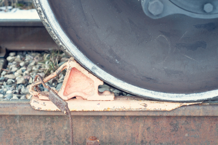 wheel chock under the train's wheel on the railroad, close-up, old rustyの写真素材