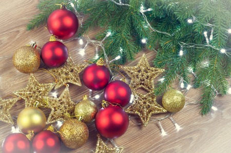 Christmas decorations in wicker baskets with fir tree branches on wooden background, balls and stars, golden and red, top view, Christmas garland lightの写真素材