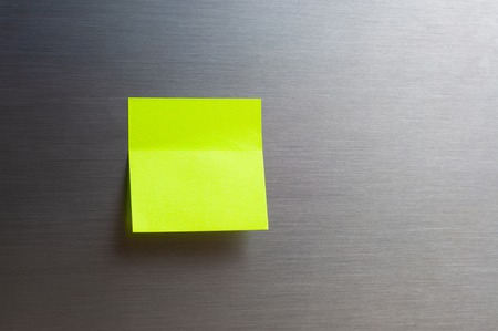 yellow sticker note on gray silver background, close-upの写真素材