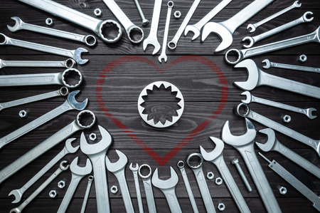 wrenches gear and a heart on a dark wooden background. Concept love for your work.の写真素材