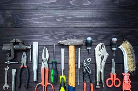 Background from various tools on a dark wooden workbench. top view. copy spaceの写真素材
