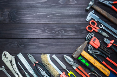 Background from various tools on a dark wooden workbench. top view. copy space