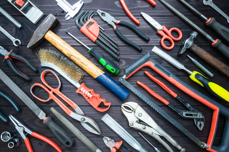 Background from various tools on a dark wooden workbench. top viewの写真素材