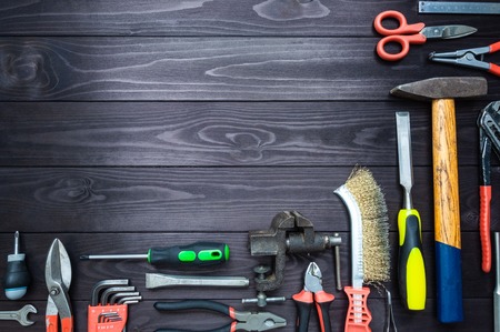 Background from various tools on a dark wooden workbench. top view. copy spaceの写真素材