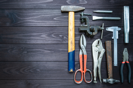 Background from various tools on a dark wooden workbench. top view. copy spaceの写真素材