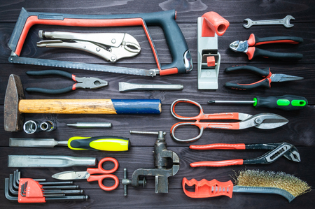 Background from various tools on a dark wooden workbench. top viewの写真素材