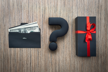 Concept choice gift or money. Envelope with dollars and black box on a wooden table.の写真素材