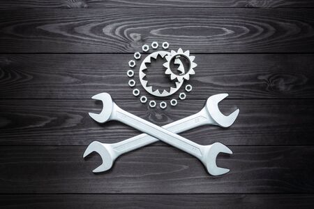 two wrenches and gears on the dark wooden background.の写真素材