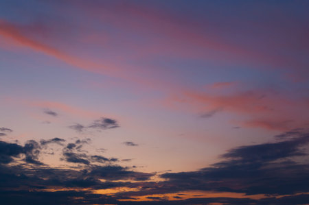 Colorful beautiful sunset sky over the horizon. Layered clouds.