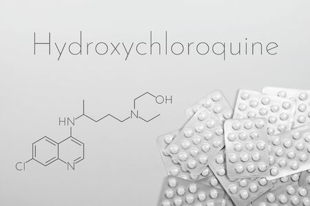 Hydroxychloroquine as possible treatment for coronavirus. Concept tablets in blister with chemical formula in white background.の写真素材