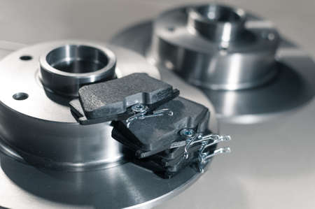 auto parts, new brake discs and pads in car service new brake discs and pads in the car service on the floor. Close upの写真素材