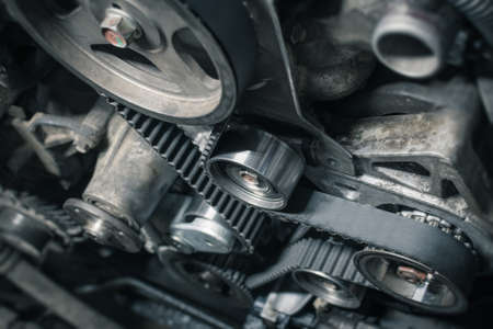 Replacement timing belt with rollers on the old diesel engine in a car service. Close up. Blur effect.の写真素材