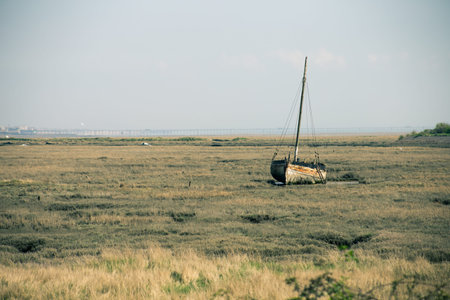 a rusting boat on low tidal grounds in Essex, UKの写真素材