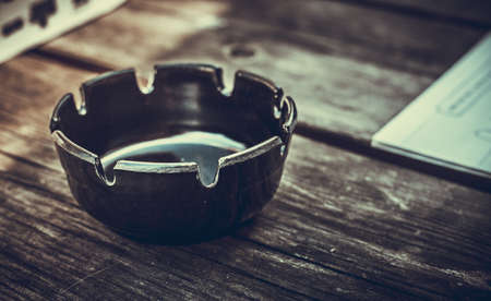 closeup photo of a black ashtray on a wooden tableの写真素材