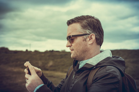 A tourist taking pictures of Hadleigh Park (Essex, UK) with his smartphone