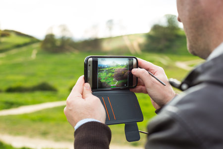 a tourist taking pictures of Hadleigh Park (Essex, UK) with his smartphone