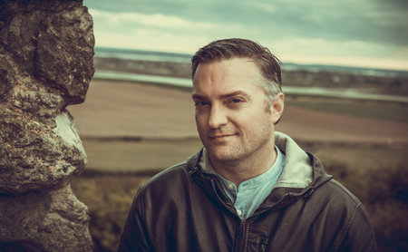 a tourist posing for a photo by the ancient walls of Hadleigh Castle, UKの写真素材