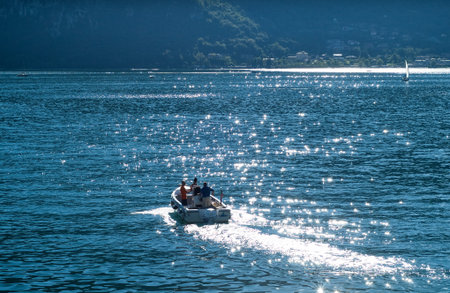 Abbadia Lariana, Italy - September 6th, 2015: three men riding a motor boat at Lake Como, Lombardy,...