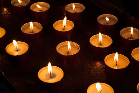 closeup photo of candles burning inside a churchの写真素材