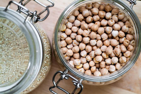 closeup photo of glass jars with chickpeas and quinoaの写真素材