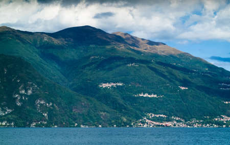 a lush and sunny mountainous view (possibly Menaggio) from the town of Varenna near Lake Como in Italyの写真素材