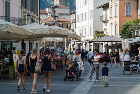 Lecco, Italy - September 1st, 2015: pedestrians walking past shops and restaurants in a central street in Lecco, Italy, photographed on September 1st, 2015.のeditorial素材