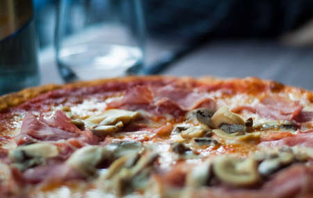 closeup of a ham and mushroom pizza photographed at an Italian restaurantの写真素材