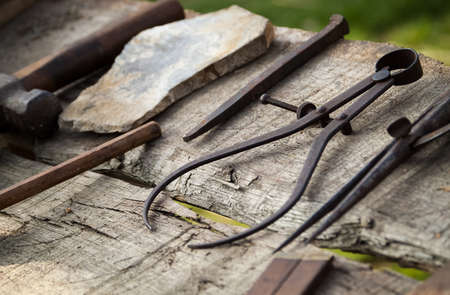 close-up photo of historical carpentry tools on a rough wooden tableの写真素材