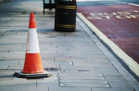 photo of a lonely road cone in the middle of the streetの写真素材