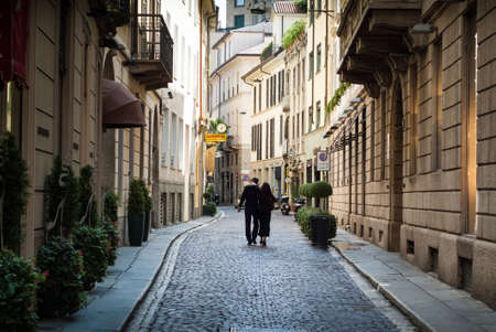 Milan, Italy - September 5th, 2015: a couple walking down a quaint street in central Milan.のeditorial素材