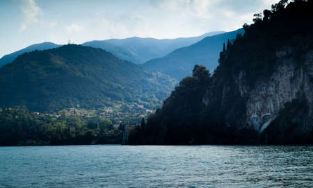 a small Italian town near Lake Como, with a silhouette of a mountain in the foregroundの写真素材