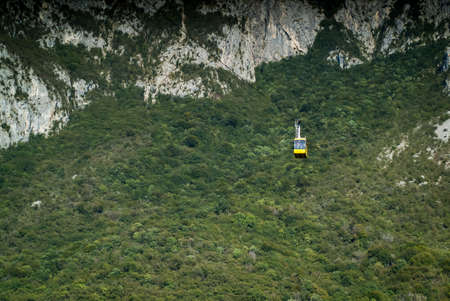 a yellow cable car carrying passengers down from Piani d'Erna (part of the Italian Alps)の写真素材