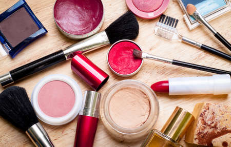 colorful makeup items scattered across a wooden surfaceの写真素材