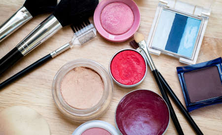 colorful makeup items scattered across a wooden surfaceの写真素材