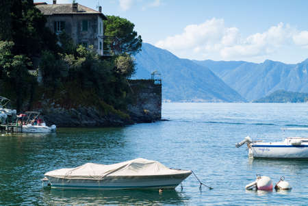 Varenna, Italy - September 4th, 2015: people embarking on a boat in Varenna (Lake Como, Italy), with more white boats in the foreground.の写真素材