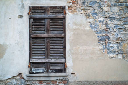 old wooden shutters on a half-ruined wallの写真素材