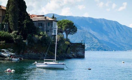 Varenna, Italy - September 4th, 2015: tourists embark on a boat in Varenna (Lake Como, Italy), with another white boat in the foreground.のeditorial素材