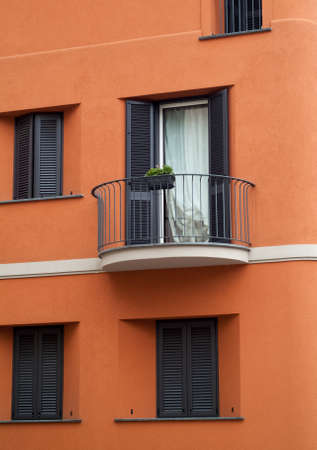 rounded balcony on a bright orange facade in Italyの写真素材