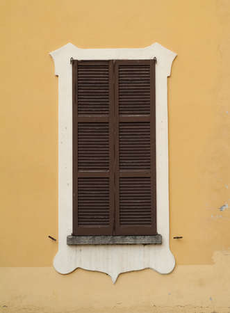 closeup photo of a window covered with brown shuttersの写真素材