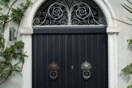 Varenna, Italy - September 4th, 2015: closeup photo of a black door with elaborate handles at Villa Monastero in Varenna, Italy.の写真素材