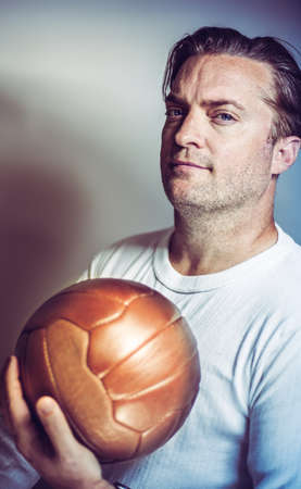portrait of a soccer coach holding a vintage ballの写真素材